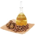 Castor oil with beans on sack over white background